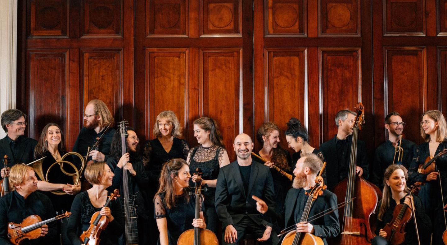 an image of the Irish Baroque Orchestra holding gathered together, holding their instruments