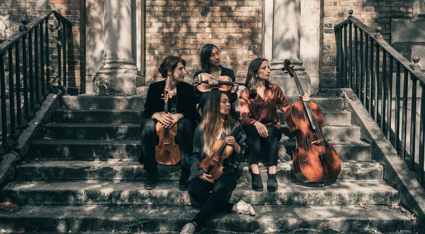 An image of the Kleio quartet sat on some stone steps