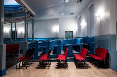 Rows of red chairs in the side stalls shown from the side