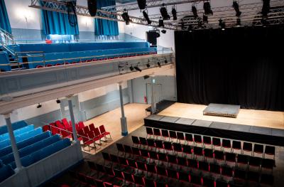 A view from above of The Queen's Hall empty stage with rows of red chairs laid out