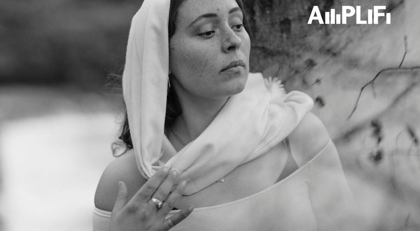 A black and white image of a woman with a light scarf draped around her head