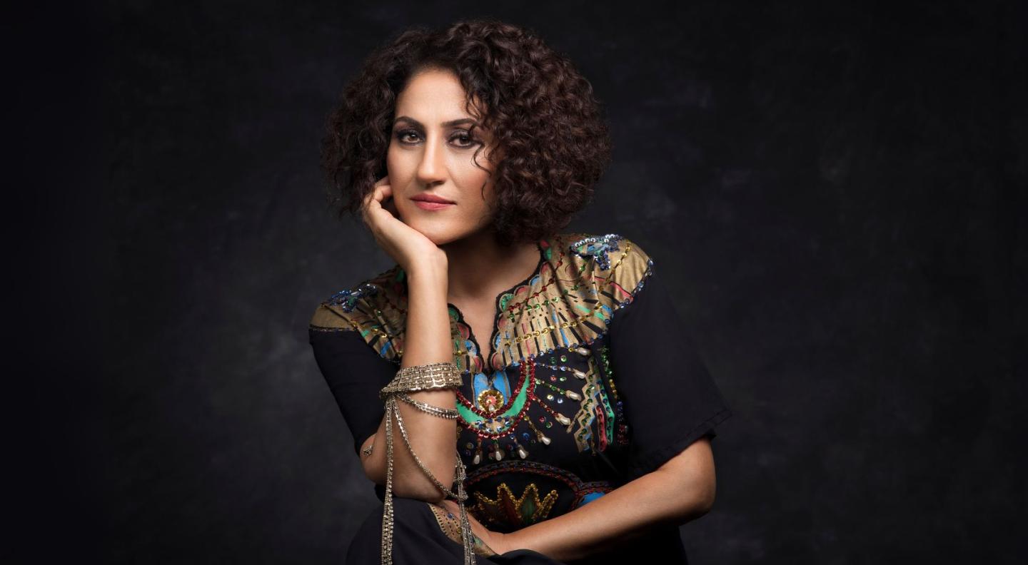 Aynur Doğan posing in front of a black backdrop