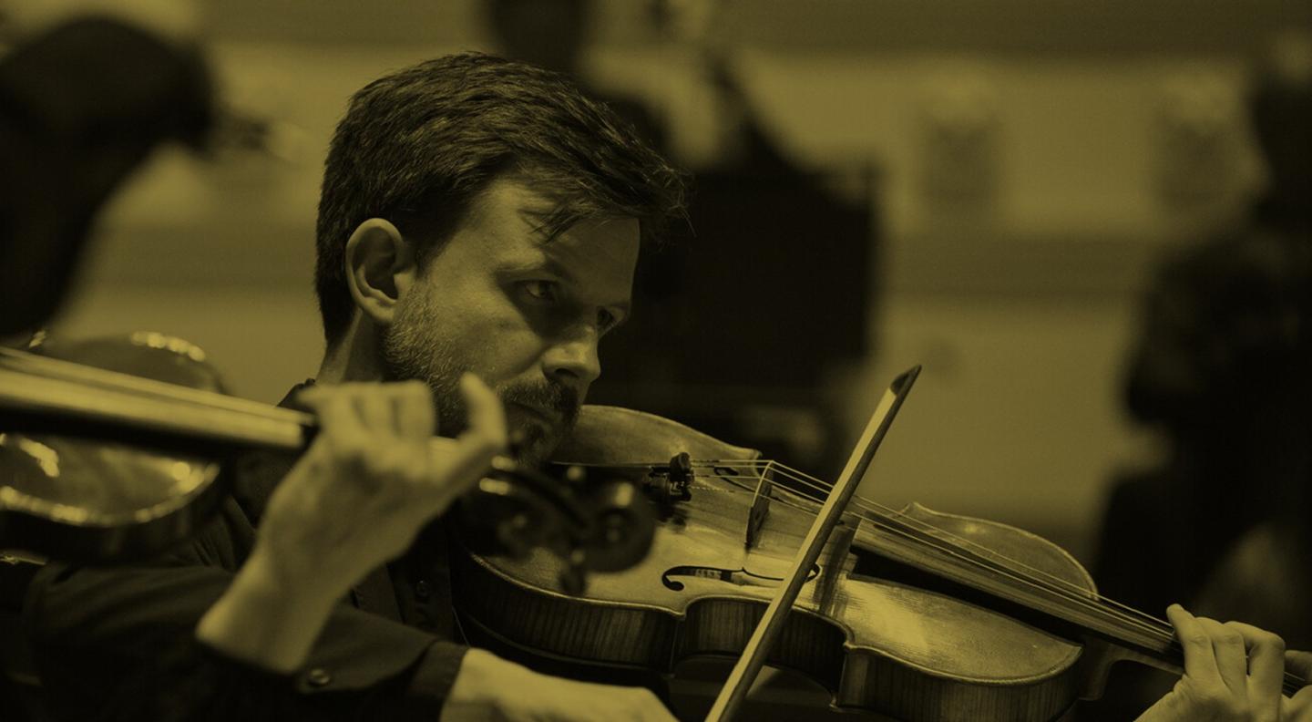 A sepia-tinted image of a man playing the violin