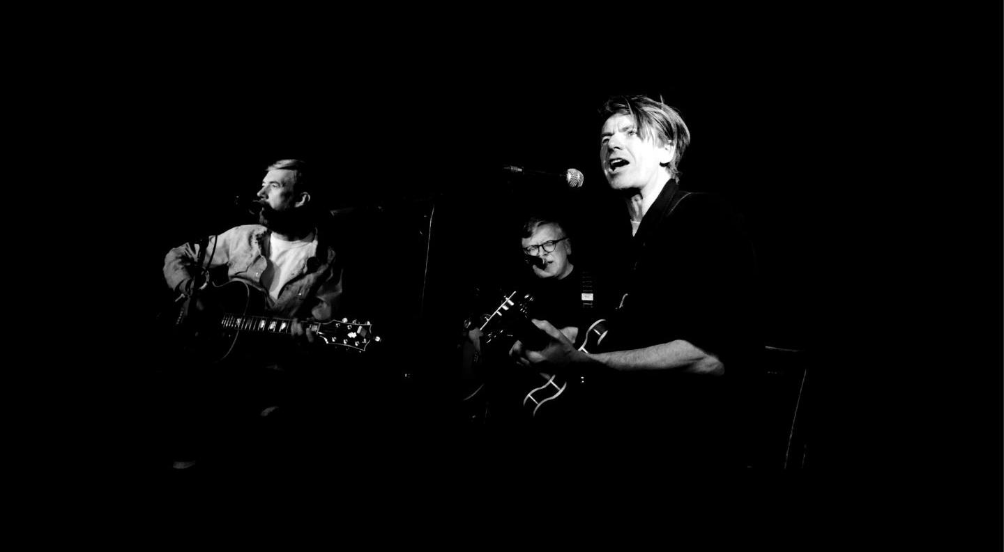 a black and white image of musicians playing on stage