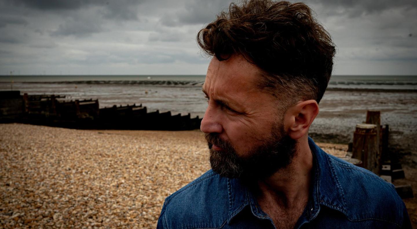 A photograph of Ross Wilson on a beach