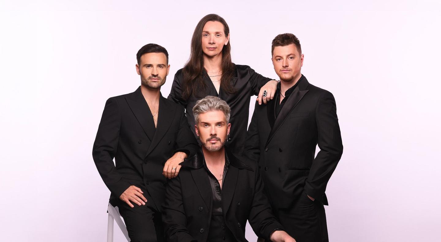 The four members of Collabro wearing black suits