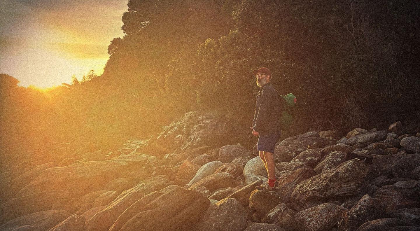 Daniel Kitson standing on rocks