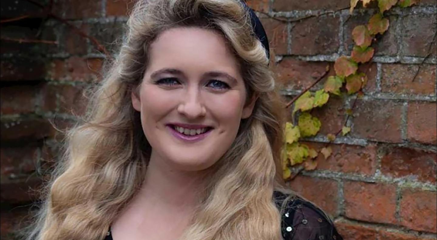 Hilary Cronin the soprano for Dixit Dominus, standing against a background of a red brick wall