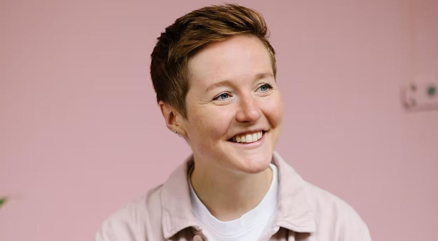 Ellie Sloarch in front of a light pink background