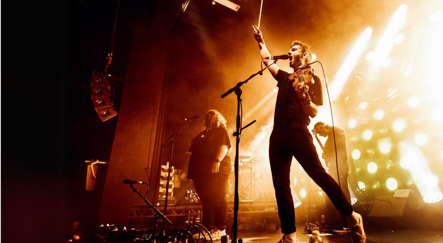 Elephant Sessions performing on stage, with yellow lighting