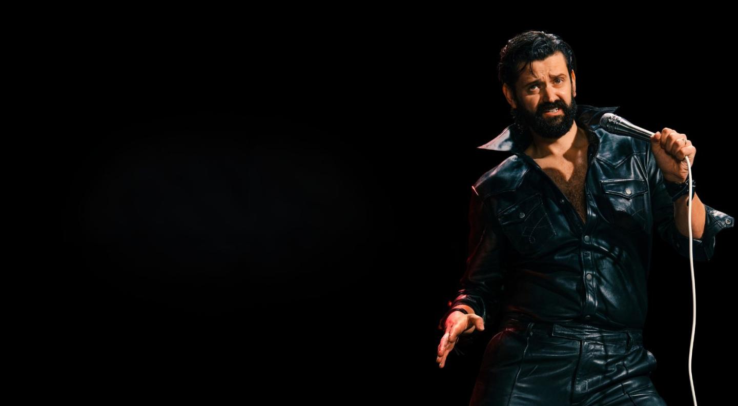 Fin Taylor wearing a black leather top in front of a black background