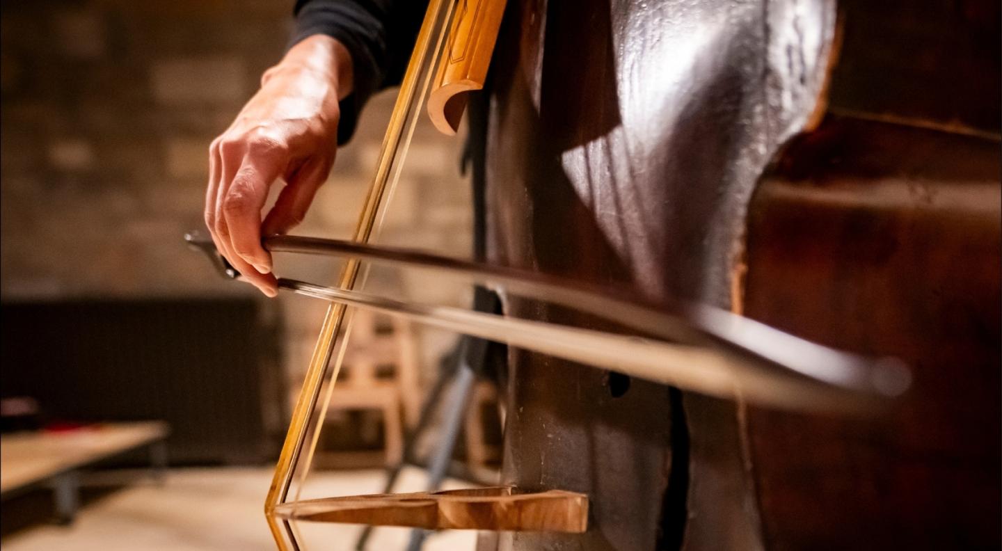 A close-up of a cello being played with a bow