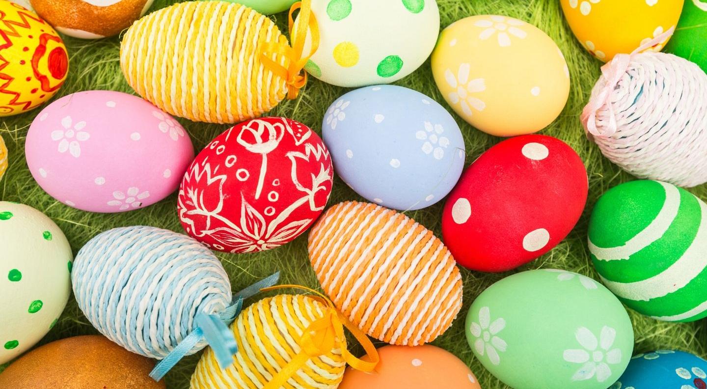Brightly coloured eggs lie on grass