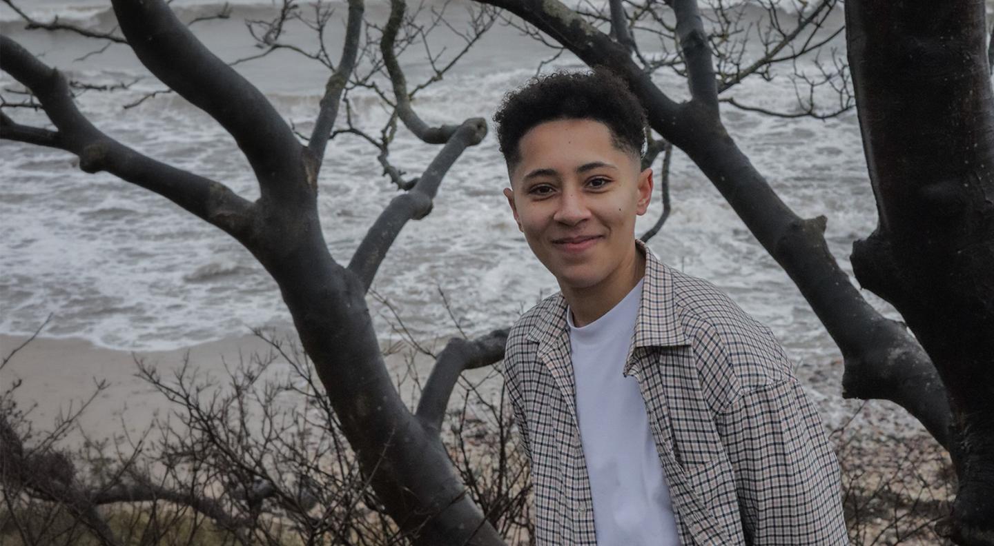 jaz riley standing outside with a tree behind. 