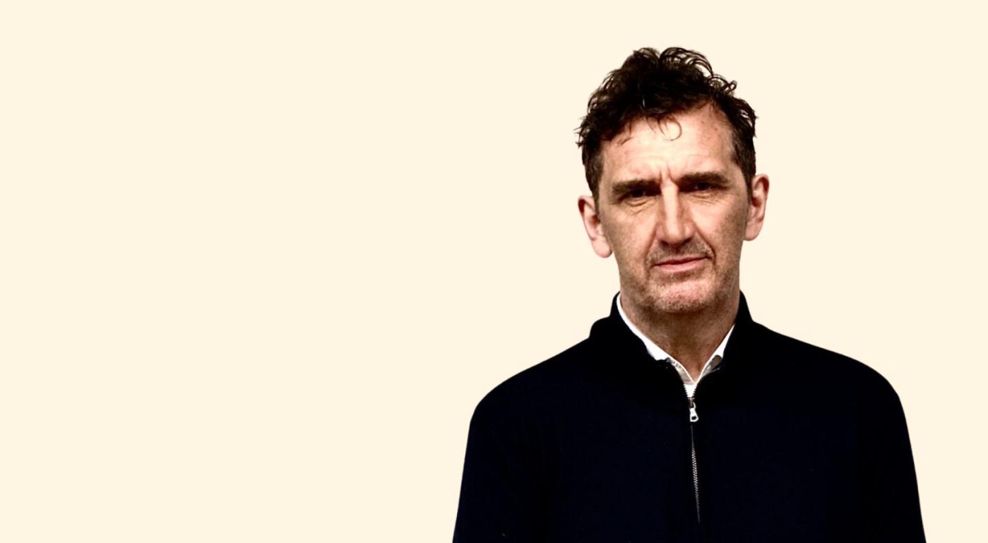 Jimmy Nail in front of a cream coloured background