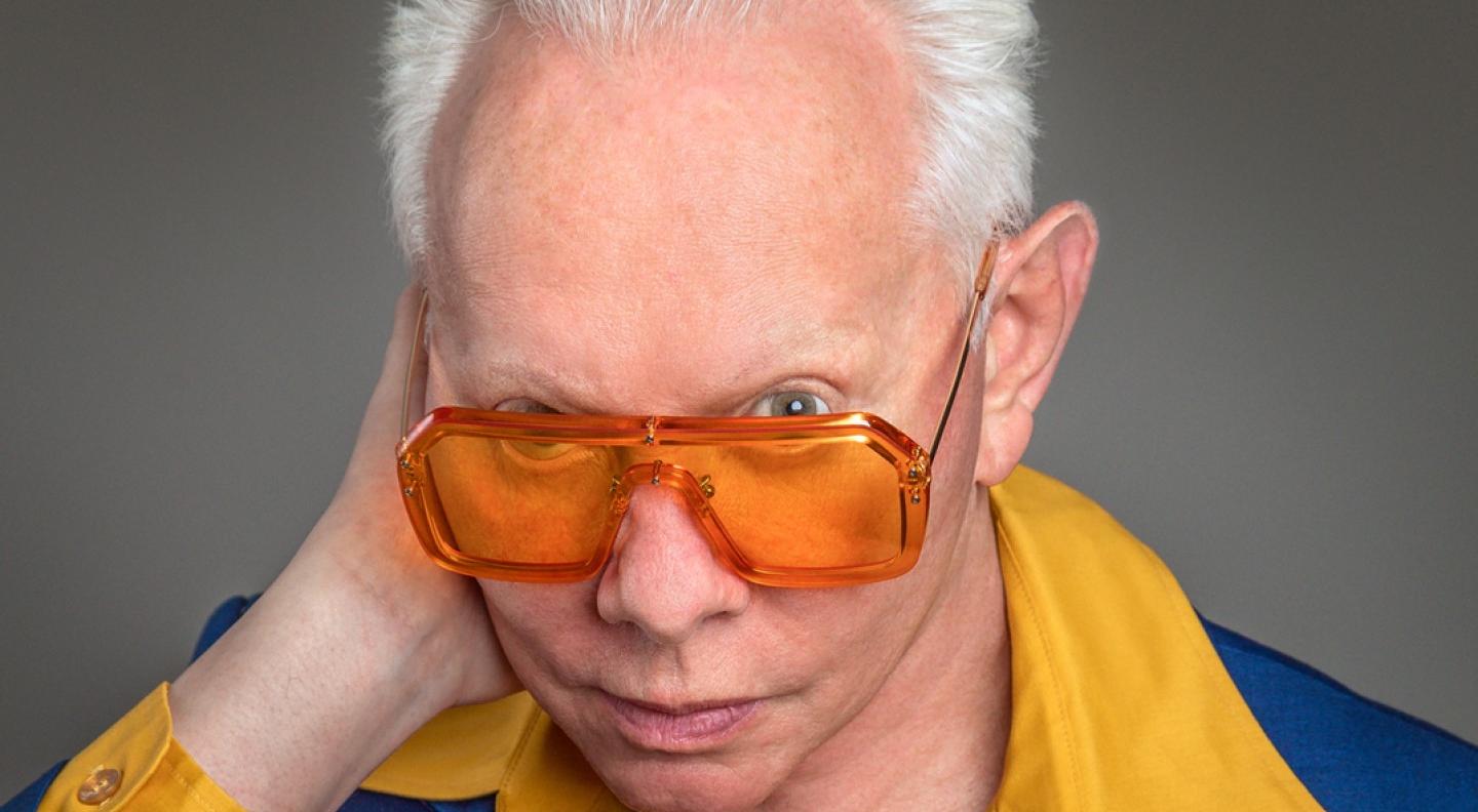 Jo Jackson peers over the top of a pair of bright orange glasses