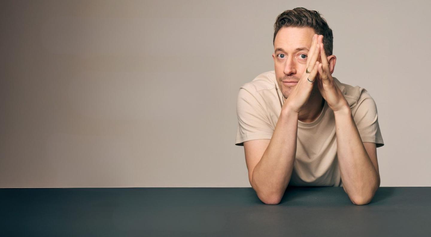 John Robins leaning on a table