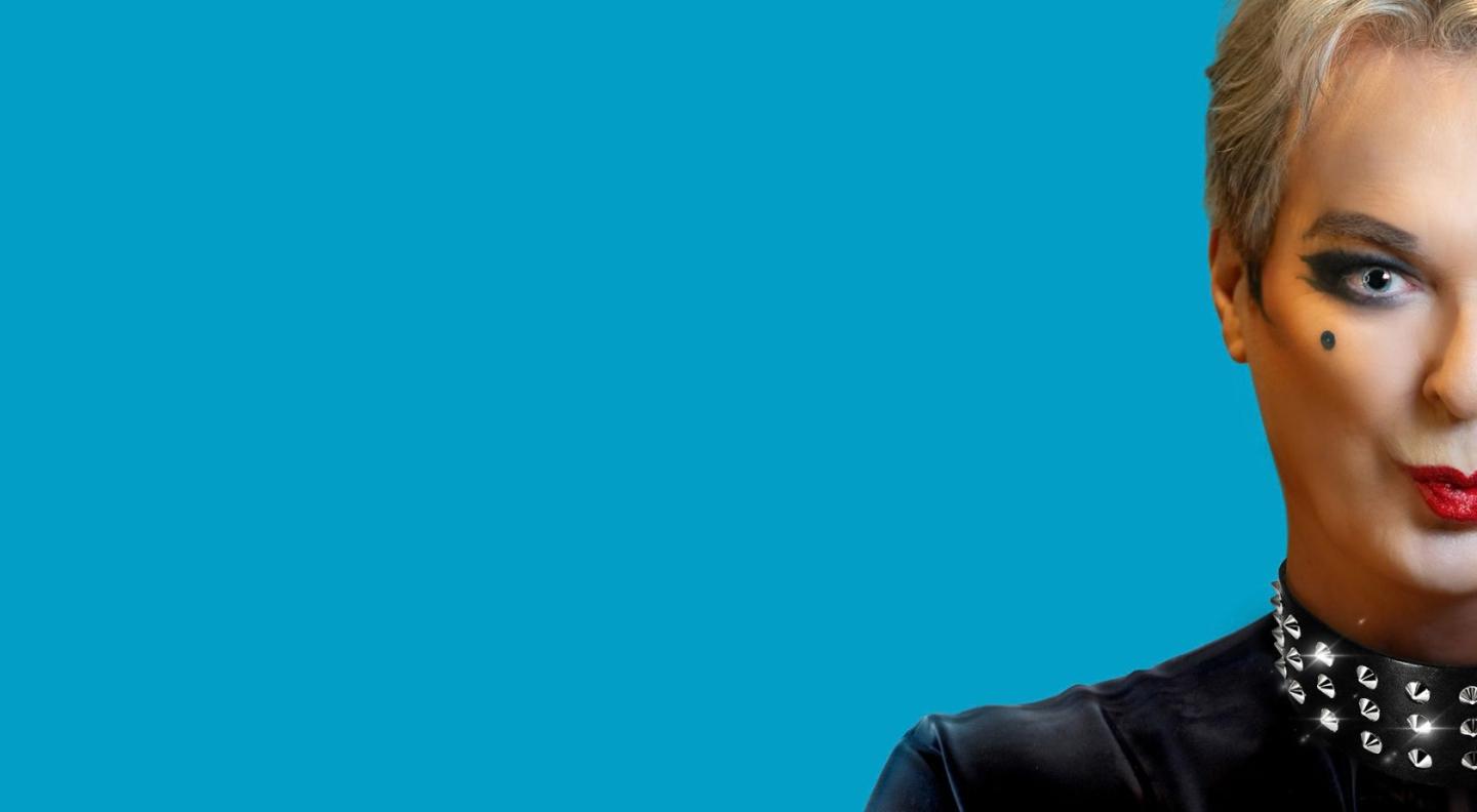 Julian Clary against a blue background