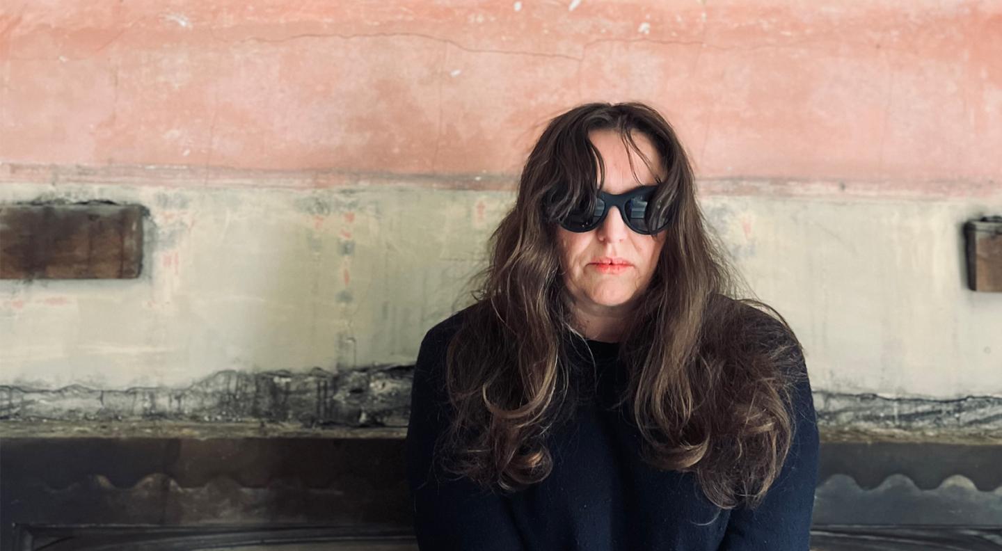 Kathryn Williams wearing sunglasses against a backdrop
