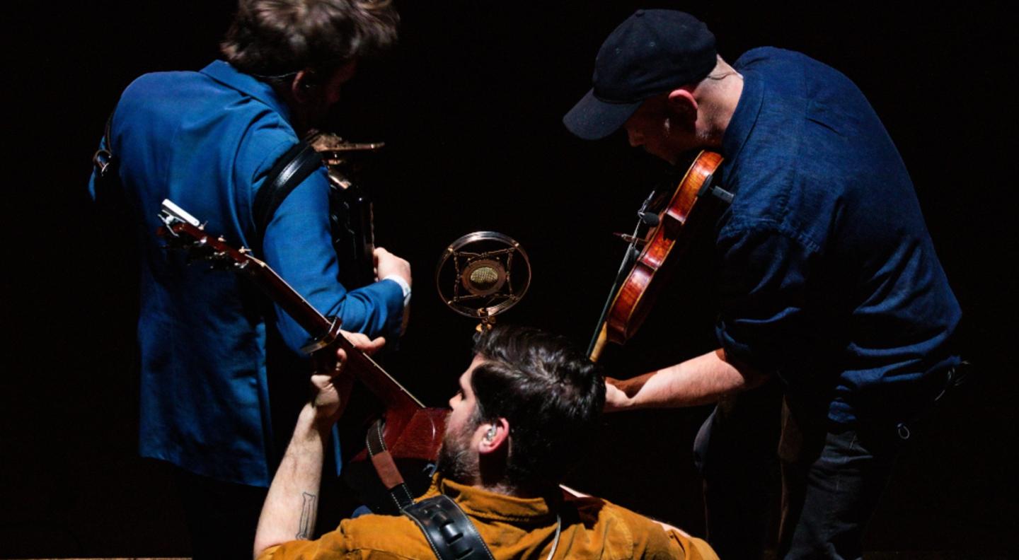 A full colour image of the three male members of Lau taken from above as they play their instruments 