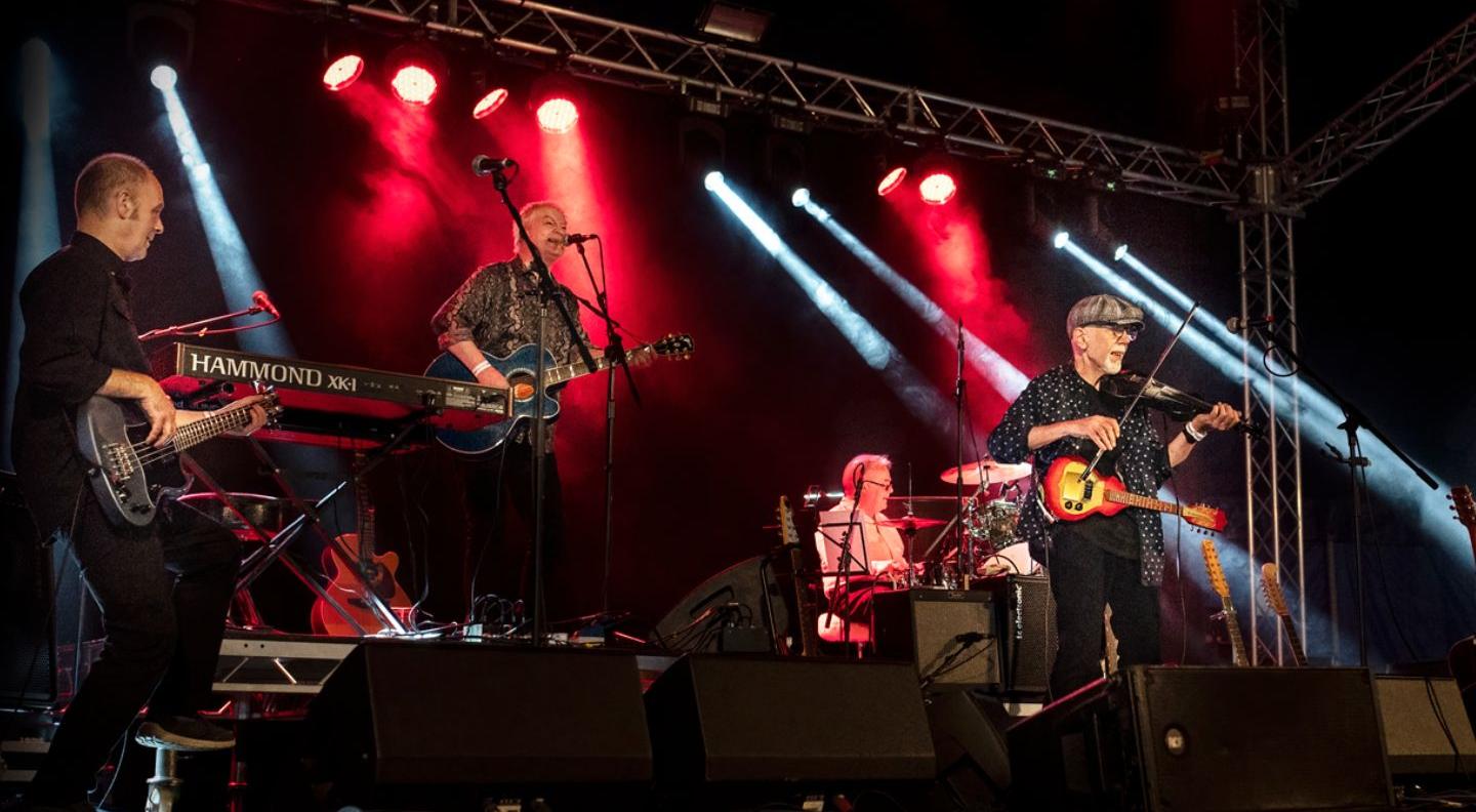 AN image of Lindisfarne performing on stage in a cathedral