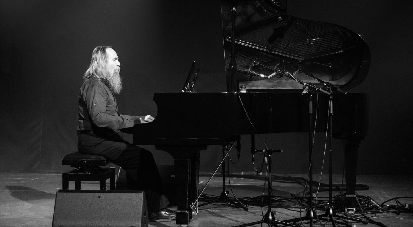 Lubomyr plays piano on a stage