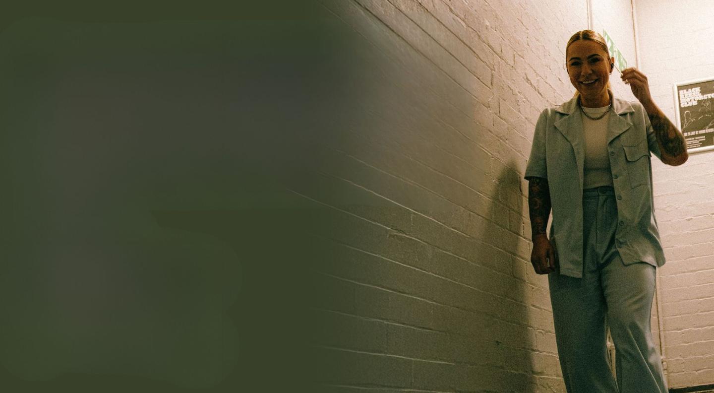 Singer Lucy Spraggan standing and smiling on a stairwell