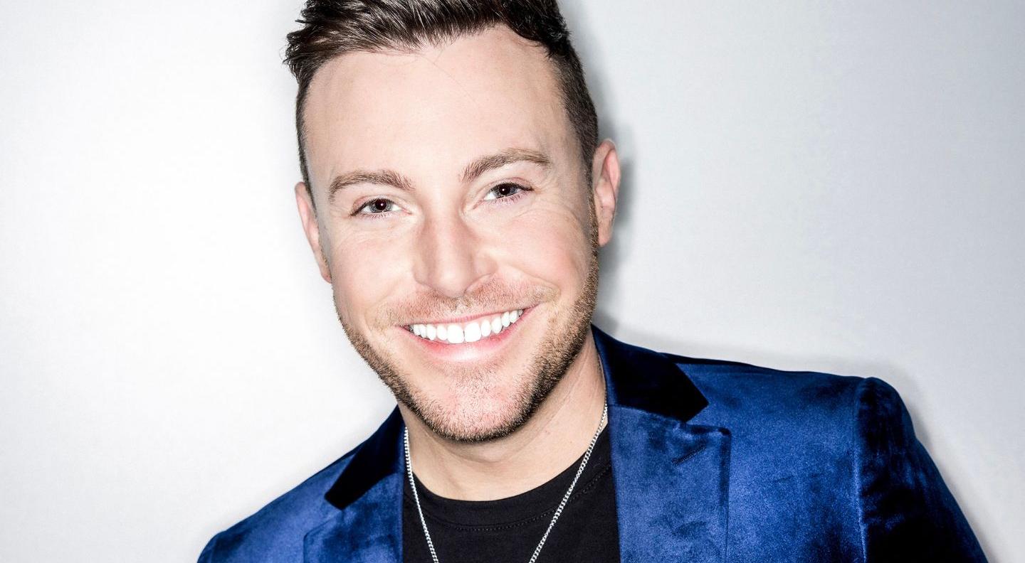 a headhsot of Nathan Carter, wearing a shiny blue suit jacket