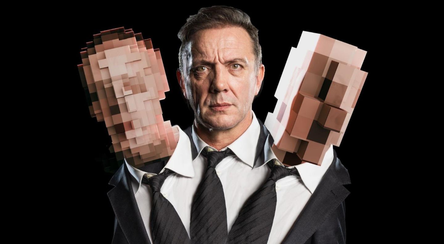 An image of Peter Serafinowicz in a suit. Coming out of each of his shoulders is another head that has been pixelated so it has no features.