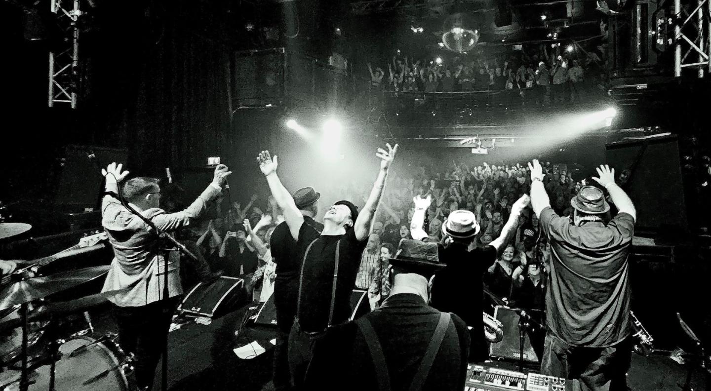 A photo of Porkpie performing in black and white