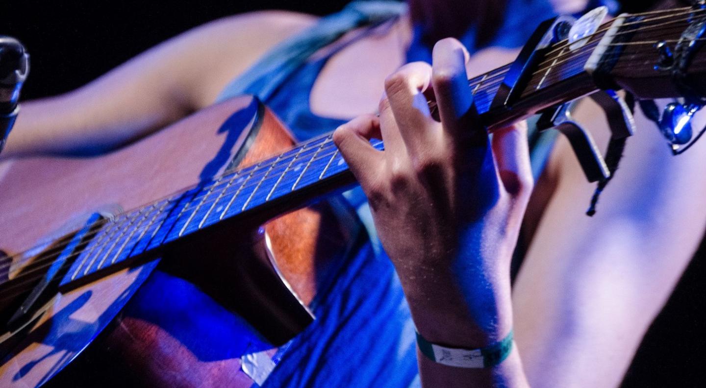 Close up of a woman playing a guitar