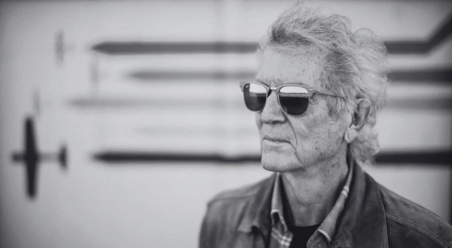 A black and white photo of Rodney Crowell wearing sunglasses