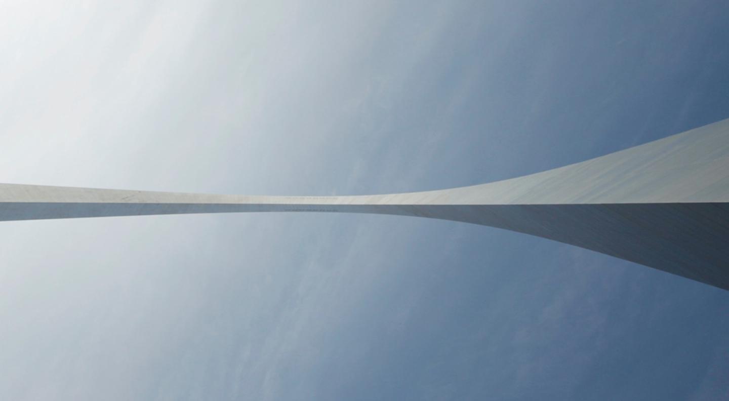 An abstract image of a white pointed shape against a blue sky-like background