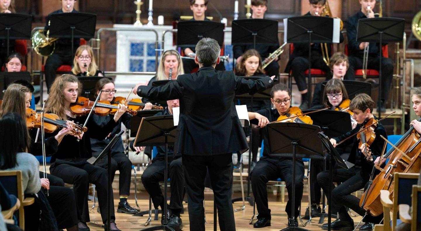 An image of a young orchestra being conducted