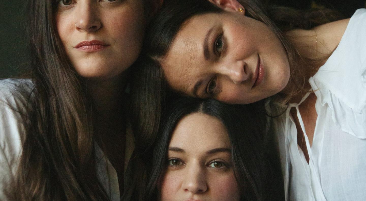 The Staves have their heads together and look out at the camera