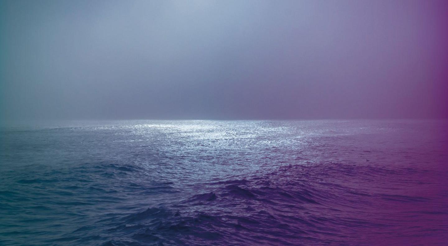 An image of a calm sea, edited in purple and blue light