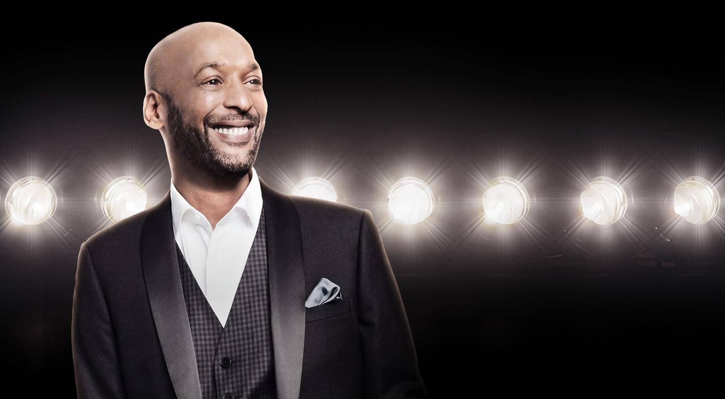 Tommy Blaize wearing a suit smiling