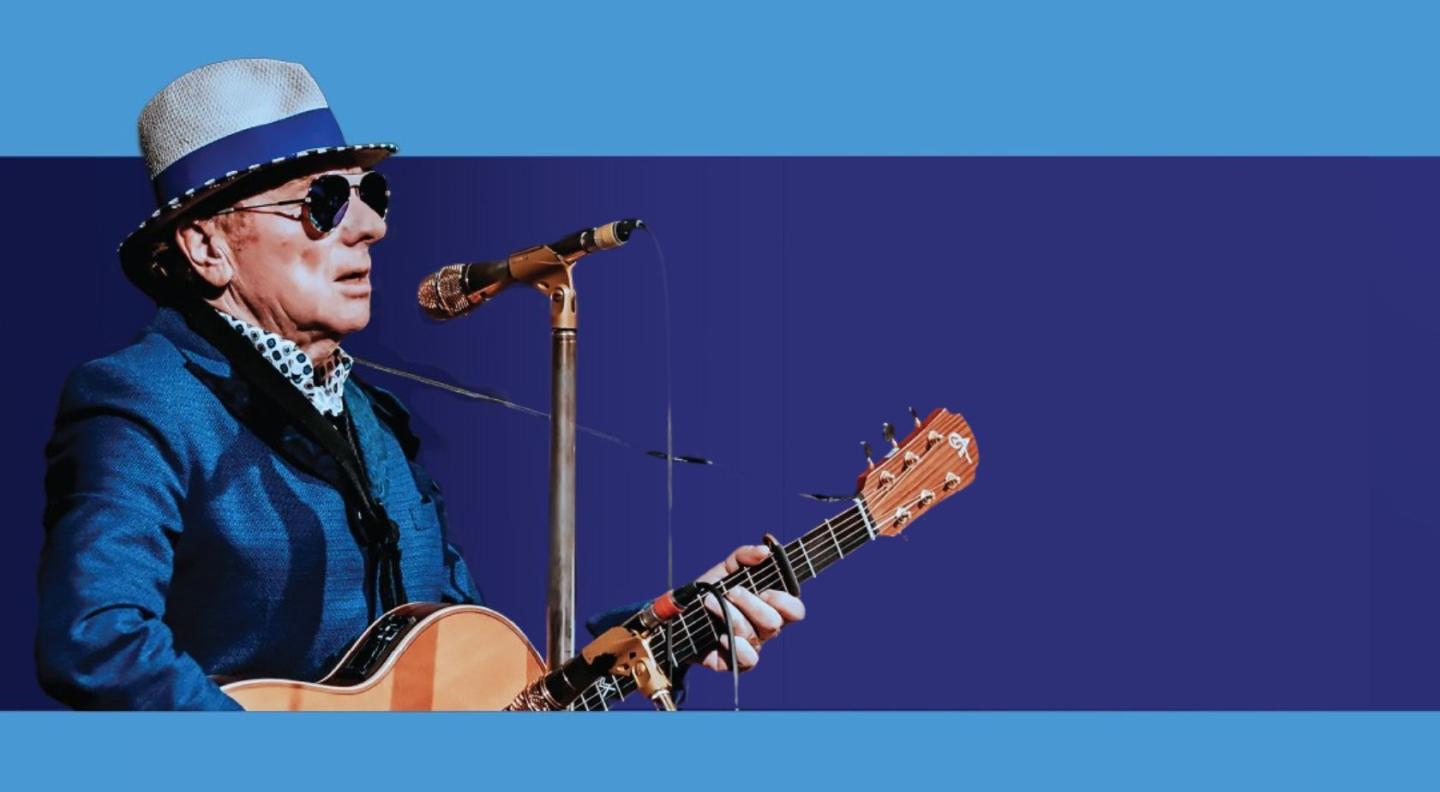 An image of a man playing guitar and singing against a blue background