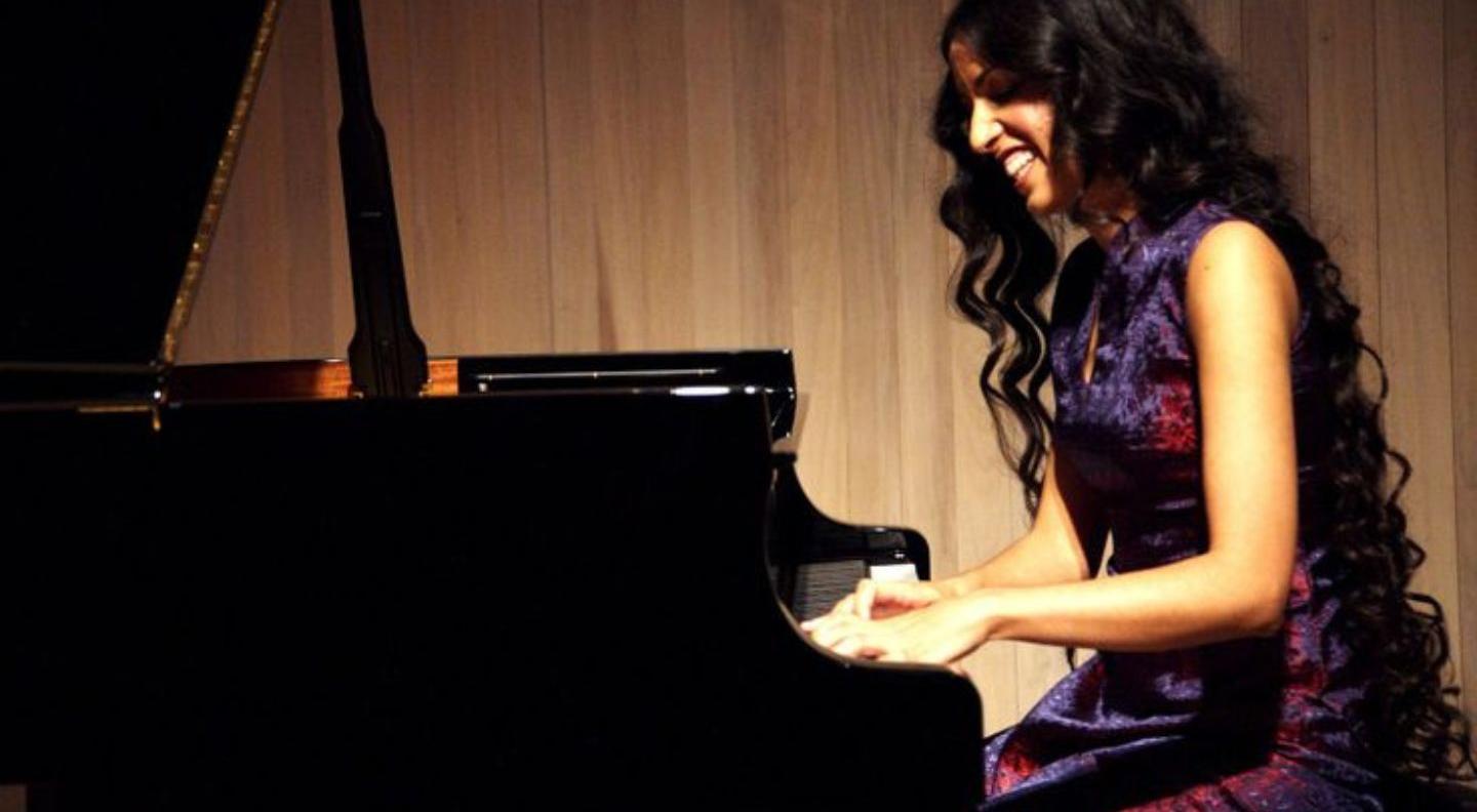 Zoe Rahman sits at a piano