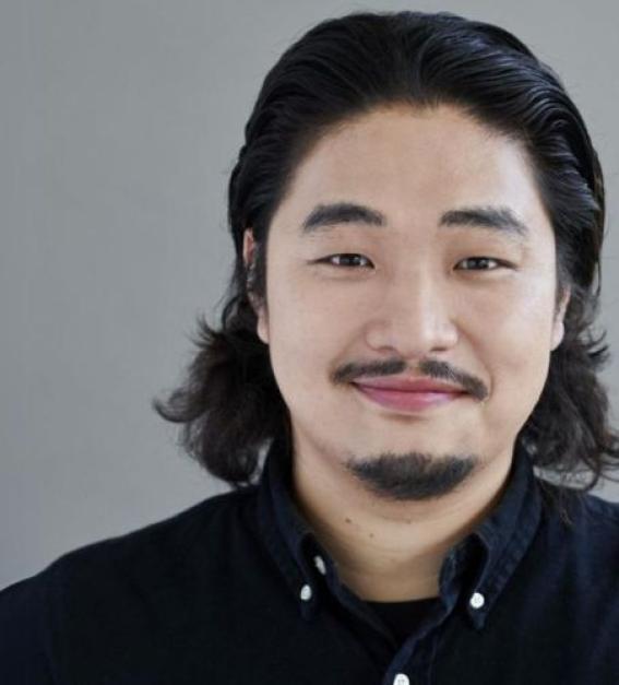 A photograph of South Korean tenor Sungho Kim, wearing a navy blue shirt