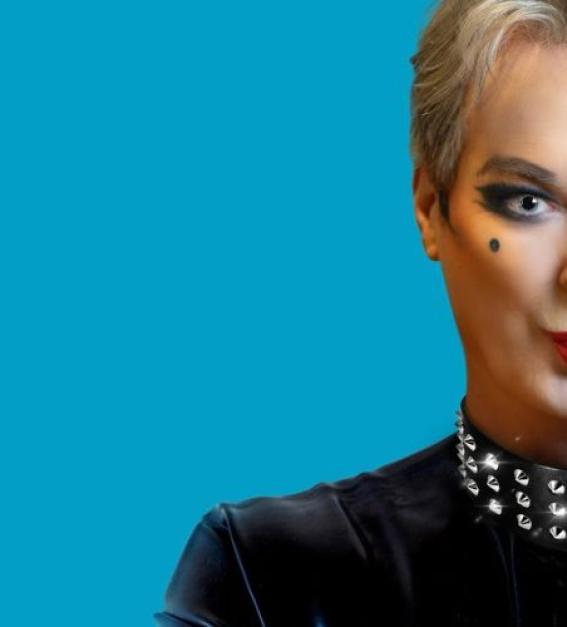 A photograph of Julian Clary against a blue background with half of his face out of the photograph