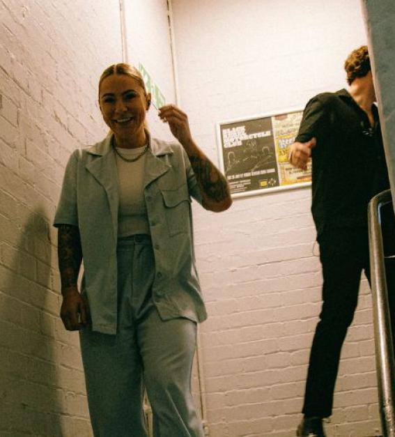 Singer Lucy Spraggan standing and smiling on a stairwell